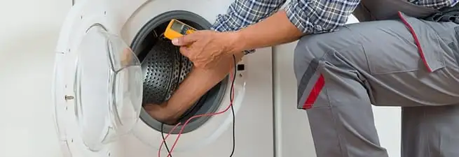 Dryer repair technician inspecting and repairing a clothes dryer in Allentown, PA