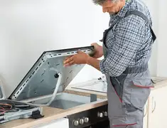 Appliance repair technician installing a built-in cooktop in Allentown, PA