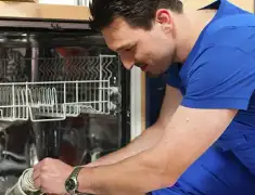 Dishwasher repair technician inspecting and servicing an open dishwasher in Allentown, PA