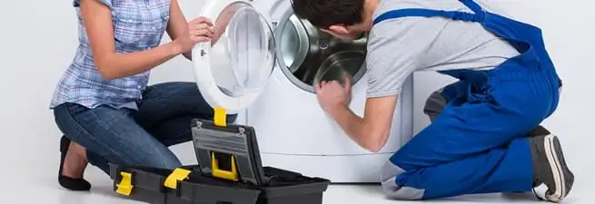 Washer repair technician inspecting a front-load washing machine with tools in Allentown, PA