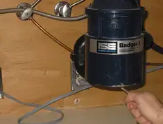 Garbage disposal repair technician tightening the mounting ring under a sink in Allentown, PA