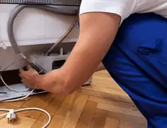 Appliance repair technician fixing refrigerator water line and connections in Allentown, PA