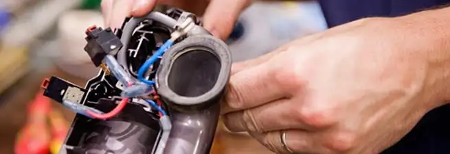 Vacuum repair technician reconnecting wiring and components in Allentown, PA