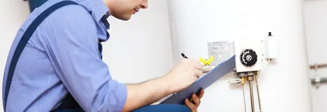 Water heater repair technician inspecting the unit and recording service notes in Allentown, PA