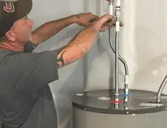 Water heater repair technician tightening supply line connections in Allentown, PA